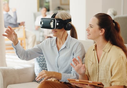Senior woman with VR headset, experiencing a headache, illustrating AR/VR use in dementia care training